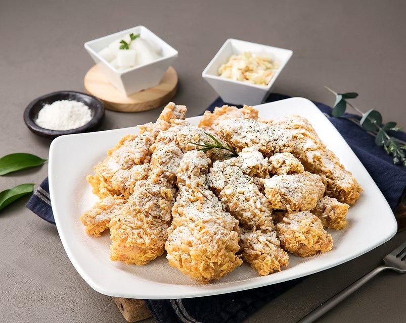 Golden crispy Korean fried chicken pieces arranged on a white plate